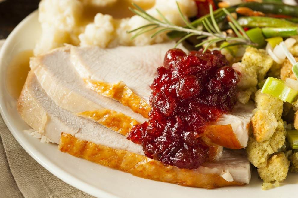 Close up of a plate of sliced turkey, cranberry sauce, stuffing and mashed potatoes. credit @skatesonthebaysf